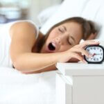 why do I sleep through alarms?