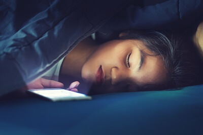 is it bad to sleep with your phone under your pillow?